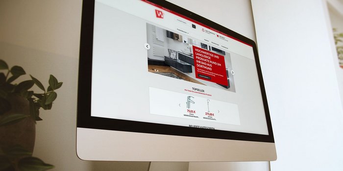 Ein moderner Computerbildschirm zeigt eine Website mit Badezimmerprodukten und einem auffälligen roten Banner.